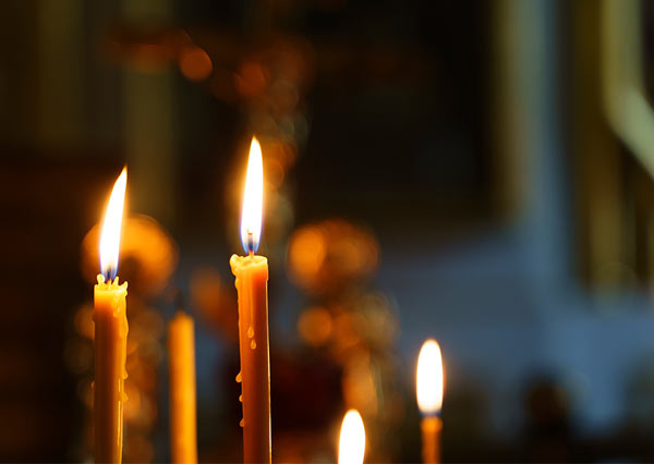 Photo of candles lit inside a cathedral